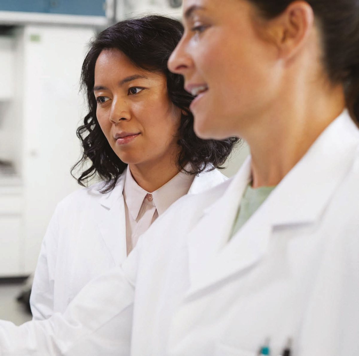 Profissionais de laboratório conversando durante a rotina de trabalho
